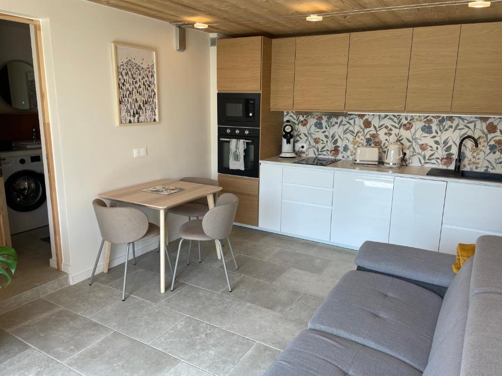une cuisine avec une table, des chaises et un canapé dans l'établissement Mountain air, à Saint-Jean-dʼArves