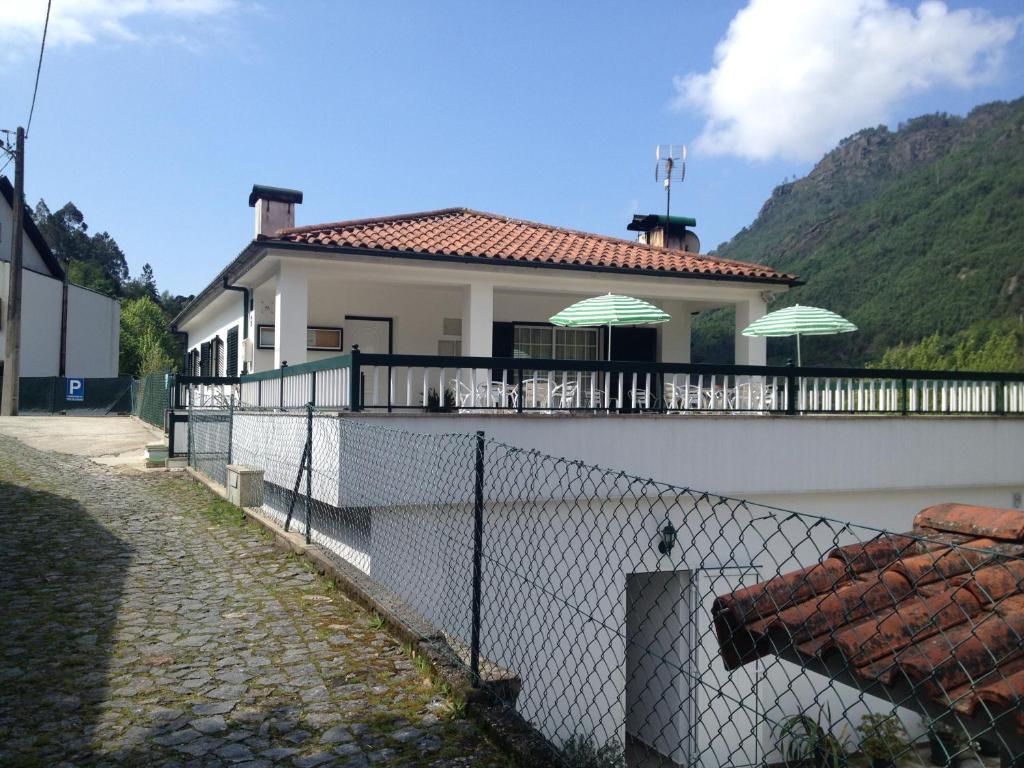 une maison avec des parasols en haut dans l'établissement Casa Lola Principe, à Gerês
