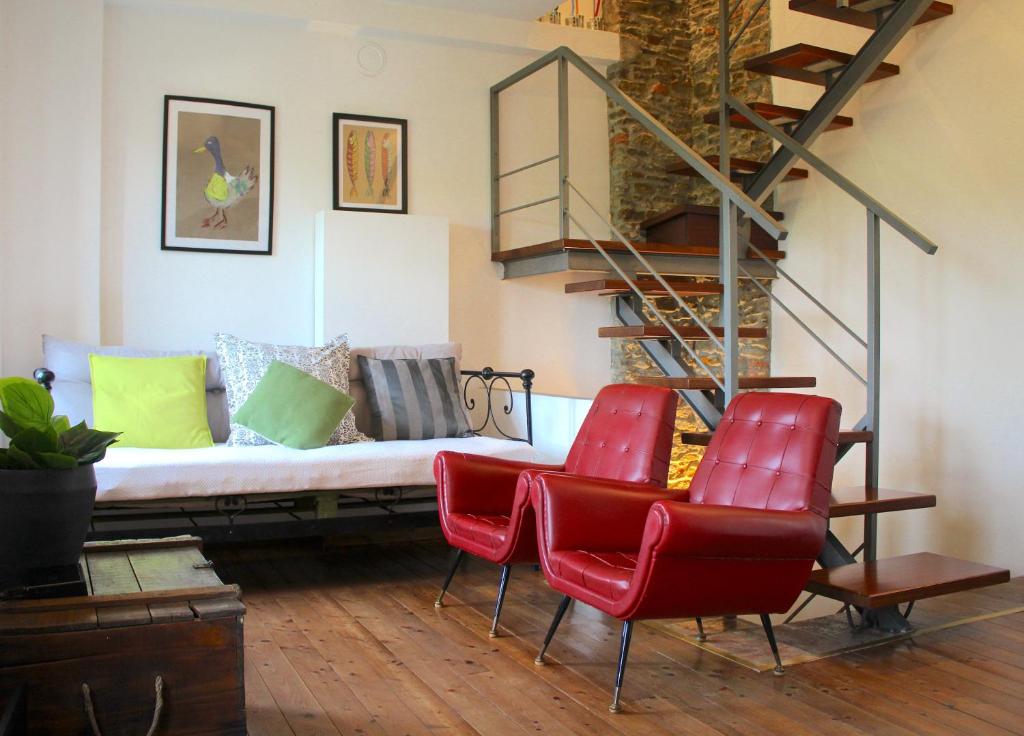 a living room with red chairs and a couch at AMAZING LANGHE AND MONFERRATO | House with garden in Calamandrana