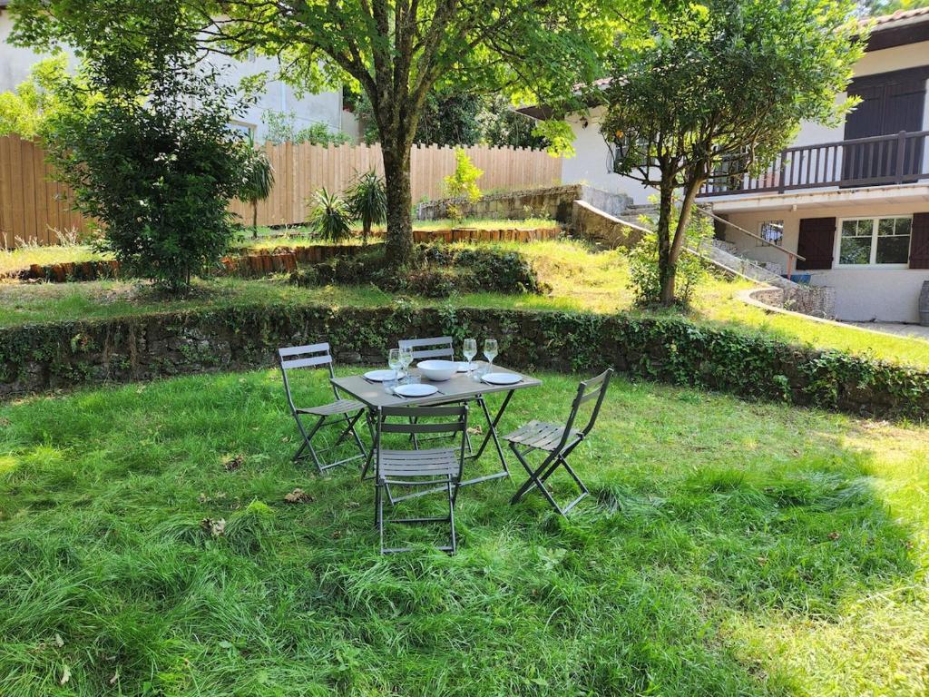 une table et des chaises dans la pelouse d'une cour dans l'établissement Appart à 100 m Arcachon Golf, à La Teste-de-Buch