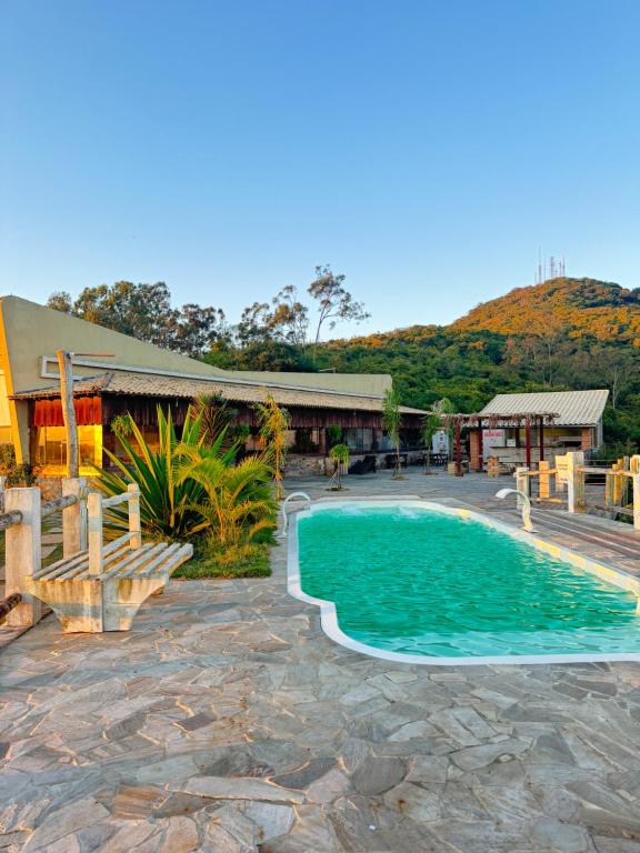 Un complejo con piscina y un edificio. en Mansão Fazendinha para grupos Arraial do Cabo, en Arraial do Cabo