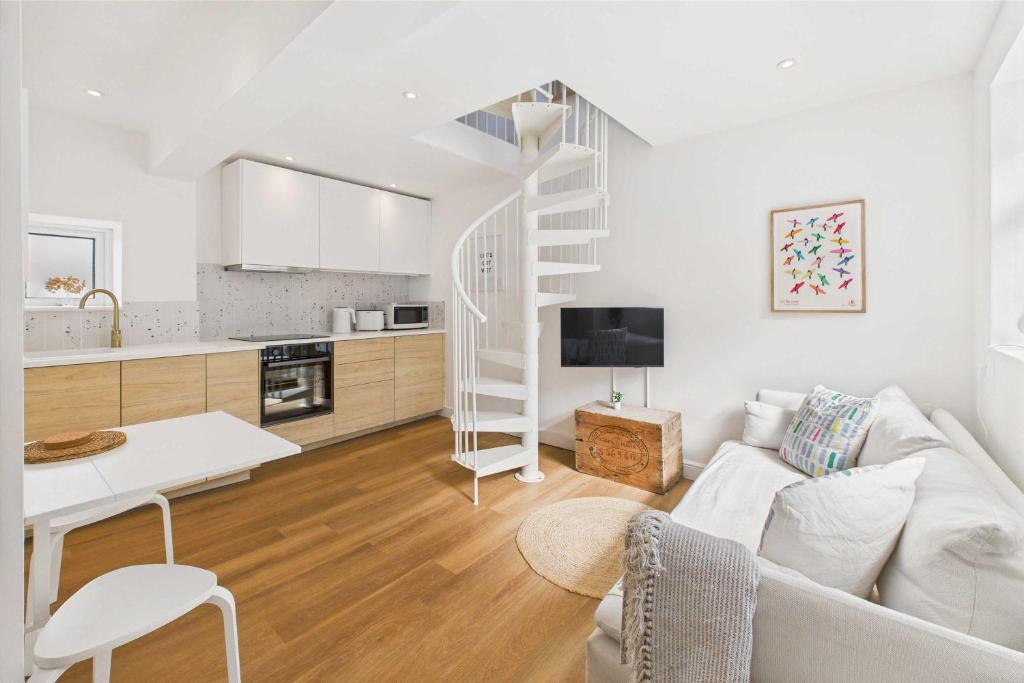 a living room with a white couch and a kitchen at Host & Stay - The Surf Shack in Saltburn-by-the-Sea