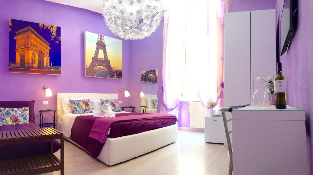 Dormitorio púrpura con cama y lámpara de araña en CityLife Rome, en Roma