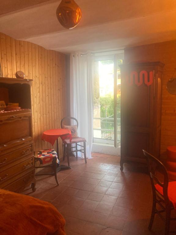 - une chambre avec une fenêtre, une table et des chaises dans l'établissement Chambre en bois, à La Turbie
