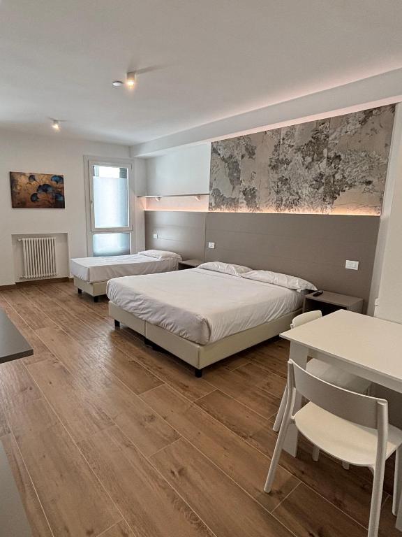 a bedroom with two beds and a table and chairs at M14 Duomo Apartments in Padova