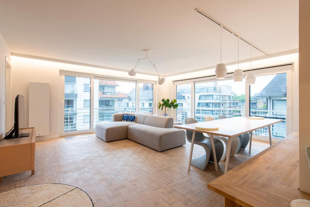 a living room with a table and a couch and a table at -Stay- at Oostduinkerke in Oostduinkerke