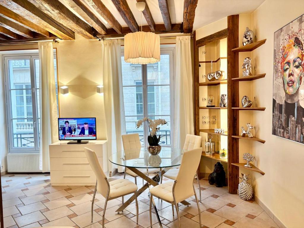 une salle à manger avec une table et des chaises en verre dans l'établissement Appartement Central St Germain, à Paris