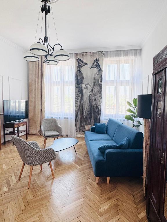 a living room with a blue couch and a table at Apartament Rynek 20 in Krosno