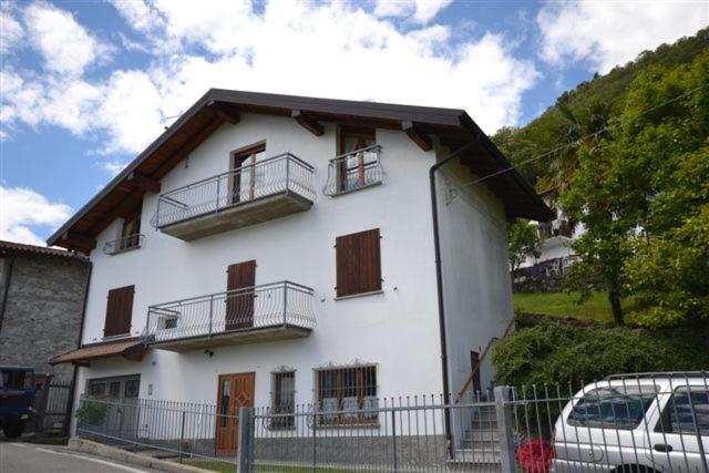 a white house with balconies on the side of it at Casa La Sorgente in Montemezzo