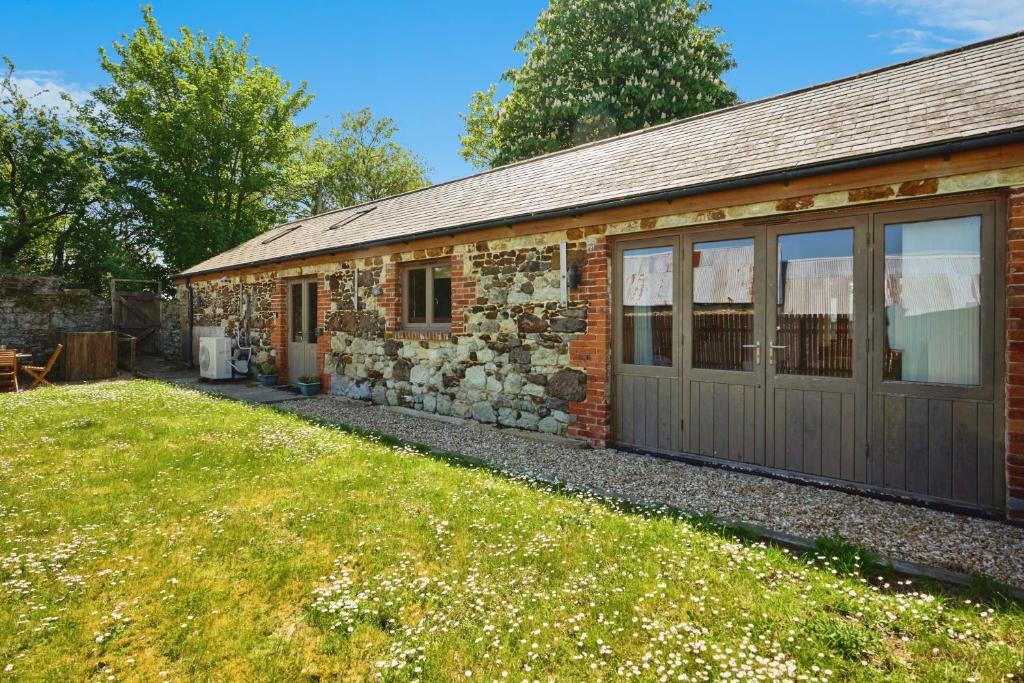 ein Steinhaus mit Garage und Garten in der Unterkunft Shiloh Cottage in Whitwell