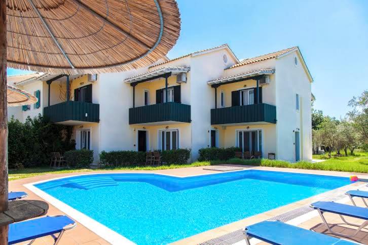 a villa with a swimming pool in front of a house at Villaaltinaapartments in Lefkada