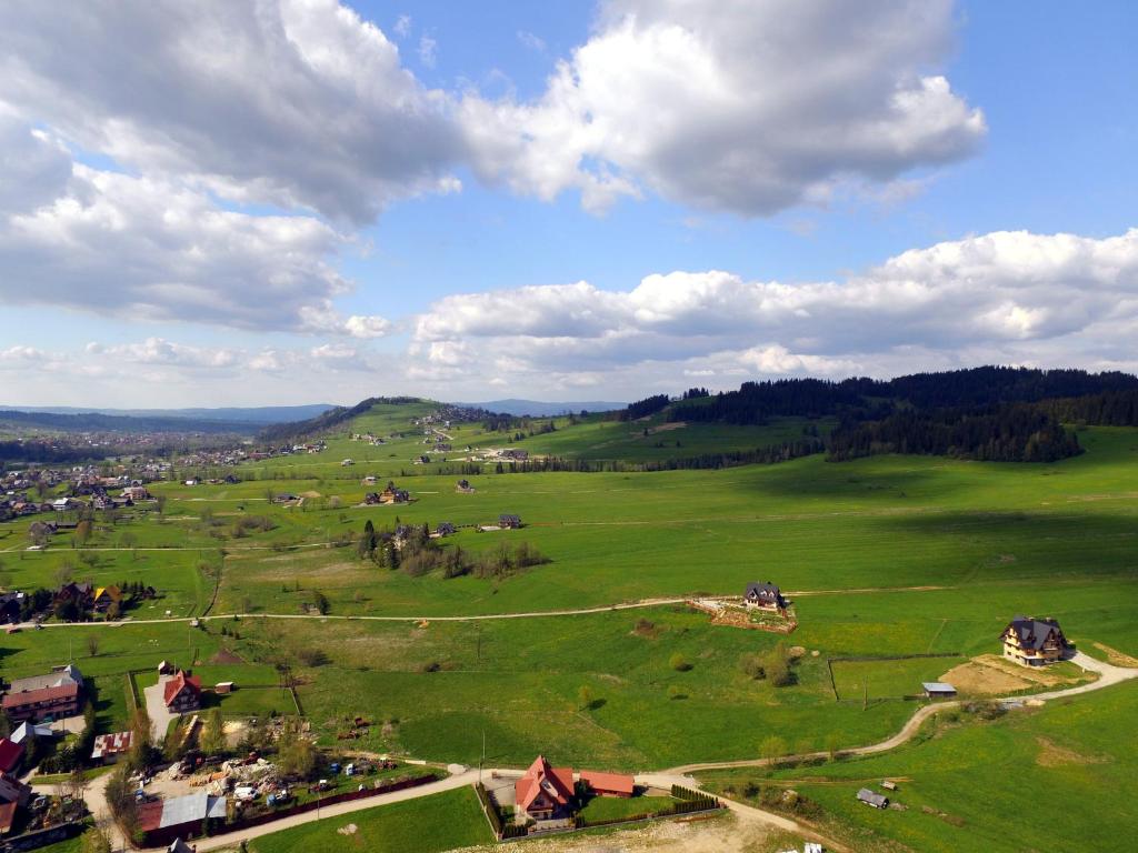 an aerial view of a green field with houses at Czarna Jagoda in Czarna Góra