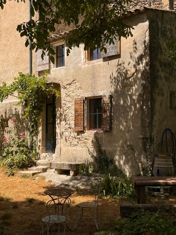 un ancien bâtiment avec une table devant lui dans l'établissement La Loube - Maison paysanne, à Buoux
