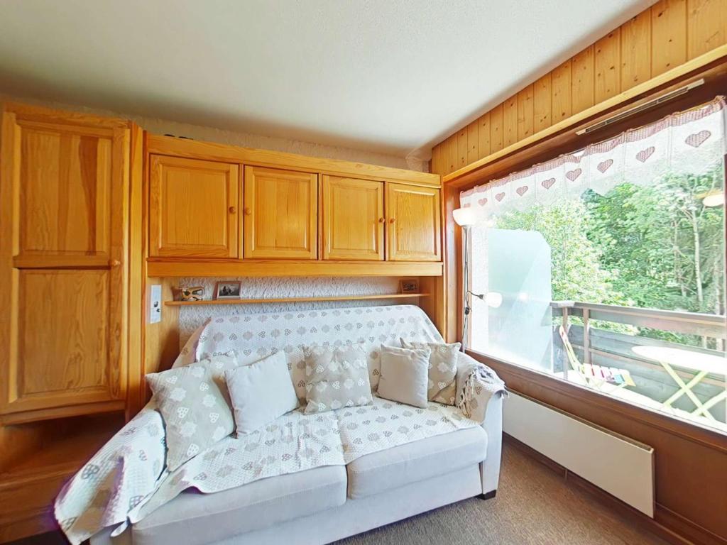 - un canapé blanc dans une chambre avec fenêtre dans l'établissement Studio cosy 4 pers avec navette et casier à skis - Grand-Bornand - FR-1-241-112, au Grand-Bornand