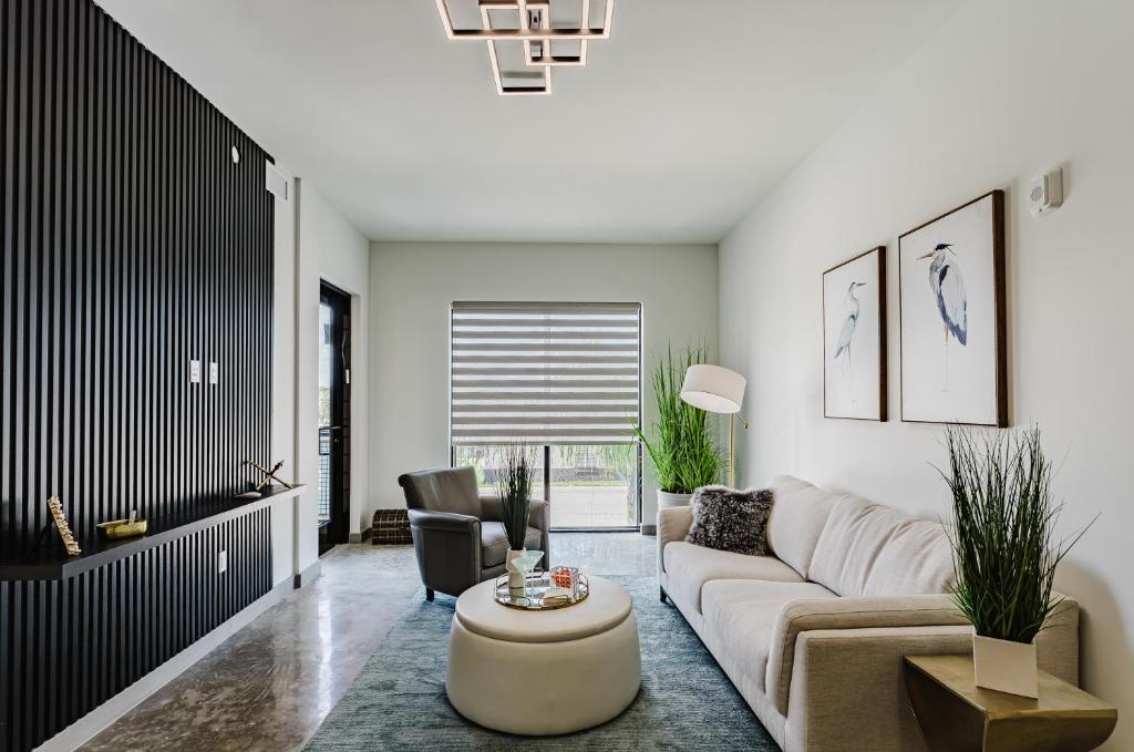 una sala de estar con un sofá y una mesa en Modern 2BR, Family-Friendly in FLL, Near Beach!, en Fort Lauderdale