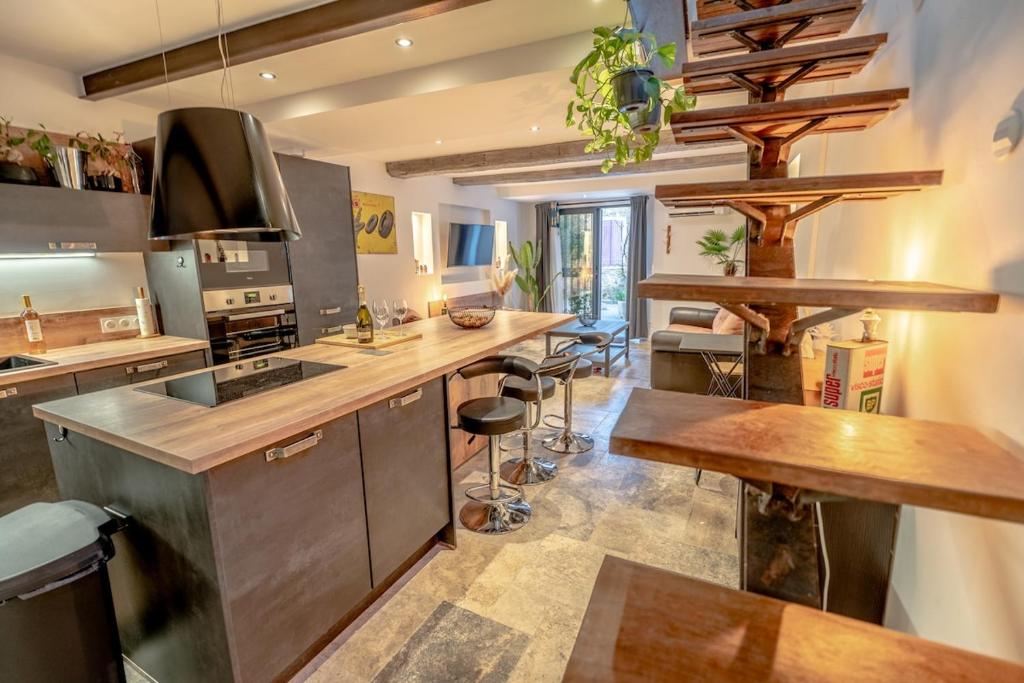 - une cuisine avec un comptoir et une cuisinière four supérieur dans l'établissement Magnifique Maison de Village climatisée, terrasse, au Plan-de-la-Tour