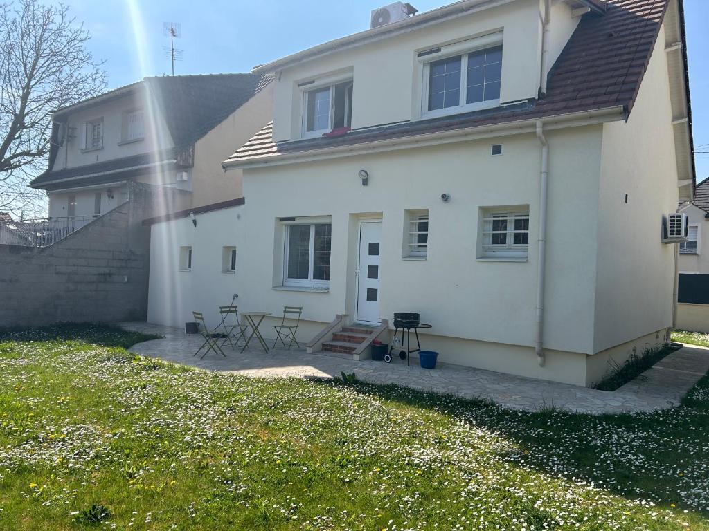 Cette maison blanche dispose d'une terrasse. dans l'établissement Maison vert galand, à Villepinte