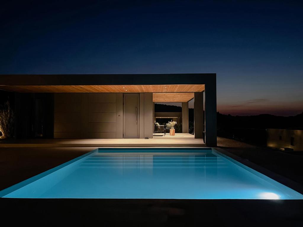 アギア・パラスカヴィにあるThe Mood Residenceの夜の家の前のプール