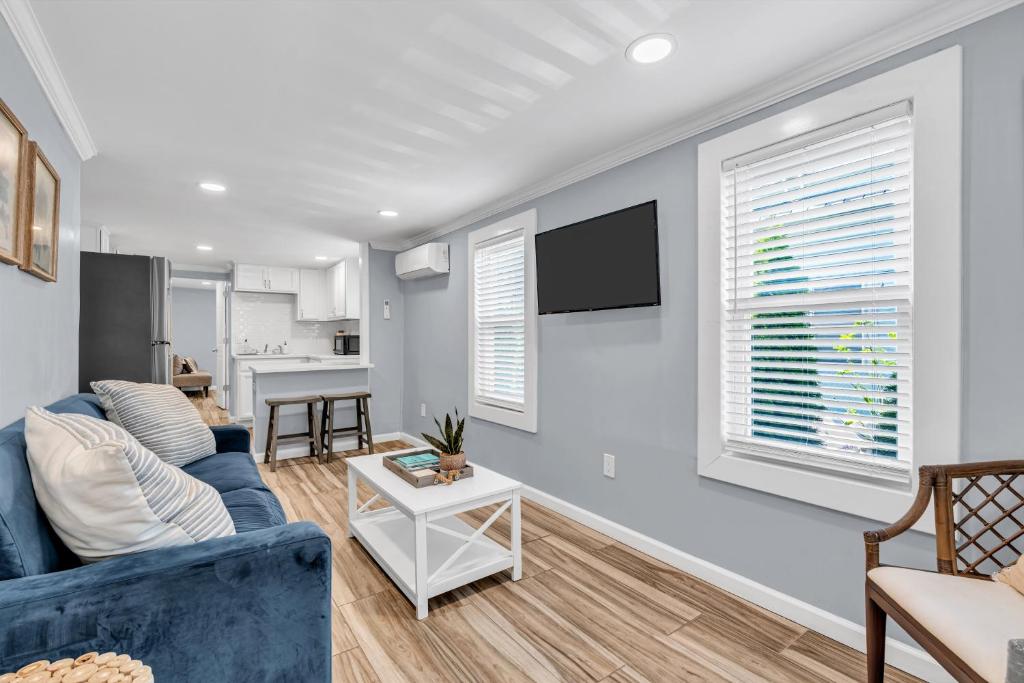 ein Wohnzimmer mit einer blauen Couch und einem Fernseher in der Unterkunft The Clark Victorian Residences in Ocean Grove