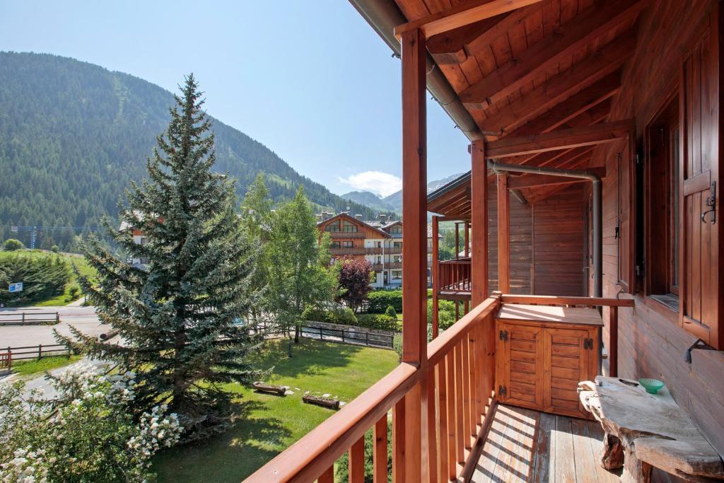 a balcony of a cabin with a pine tree at Casa Caterina La Thuile in La Thuile