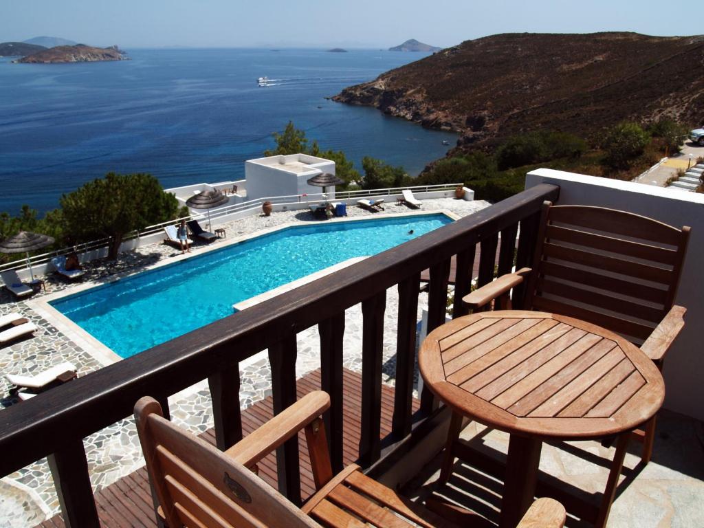 a balcony with a chair and a swimming pool at Patmos Paradise Hotel in Kámbos