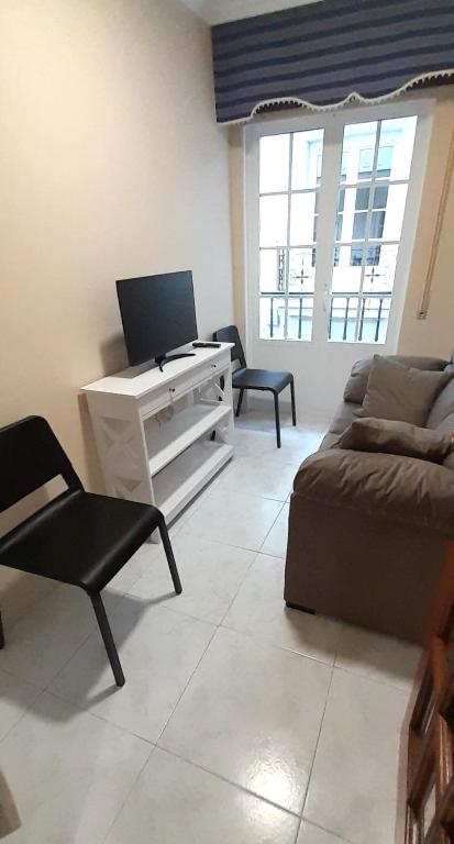 a living room with a couch and a desk at EnViveiro Casco Histórico in Viveiro