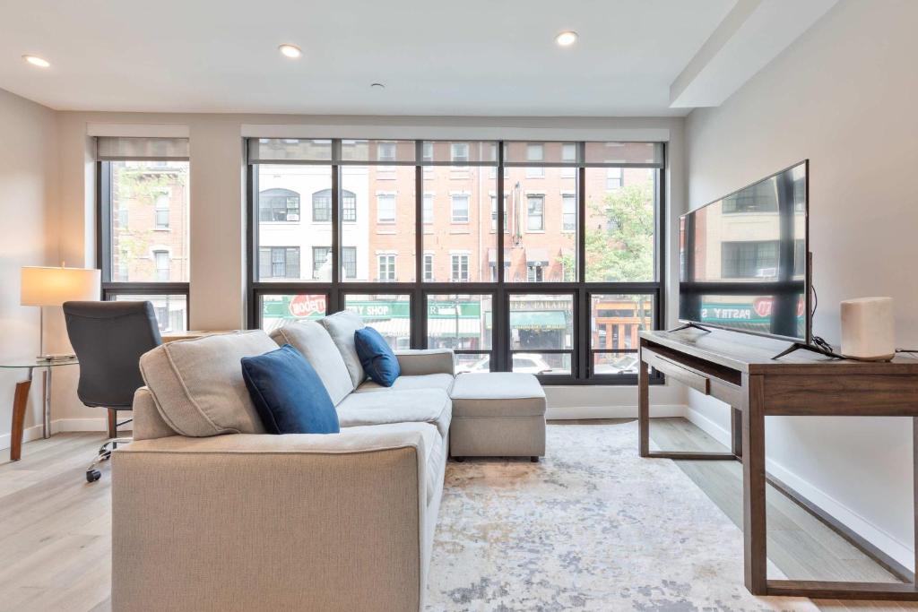 a living room with a couch and a piano at Luxury 2BR North End Retreat in Boston