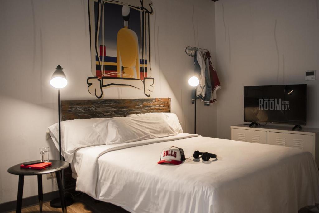 a bedroom with a bed with a hat and shoes on it at room00 Ventura Hostel in Madrid