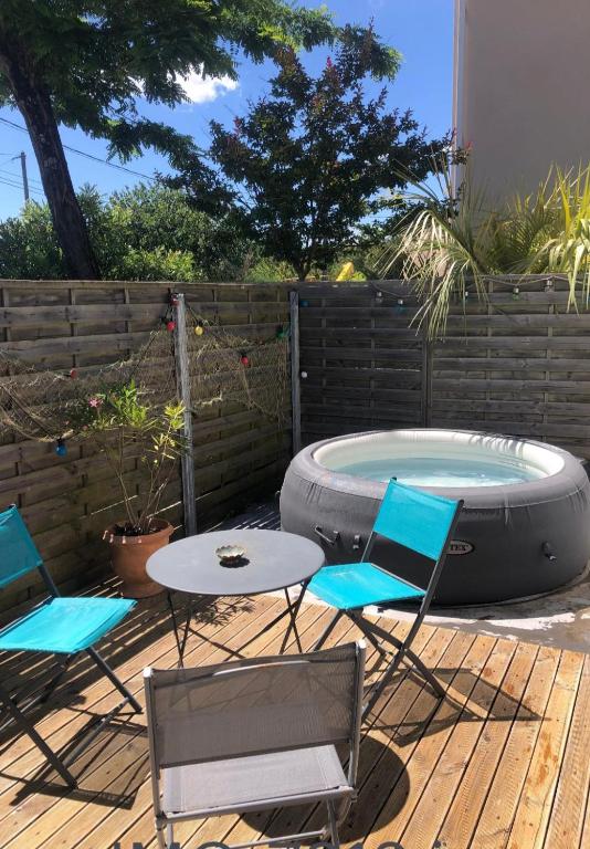 d'une terrasse avec une table, des chaises et une baignoire. dans l'établissement Maison climatisée et Studio au calme à Royan, à Royan
