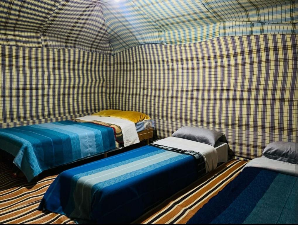 メルズーガにあるMerzouga Nomad Campのベッド2台と椅子2脚が備わる客室です。