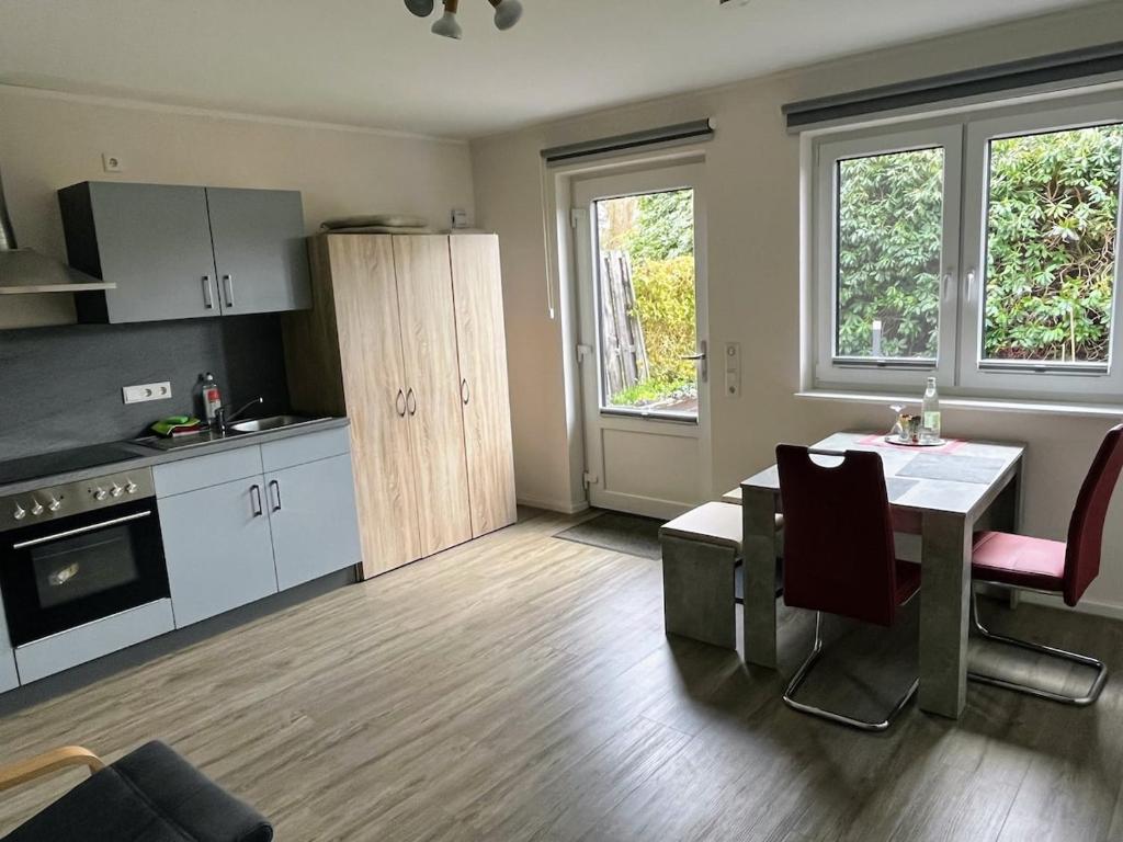 a kitchen with a table and a dining room at Hempen Fied Gästehaus - Apartment 2 in Bad Zwischenahn