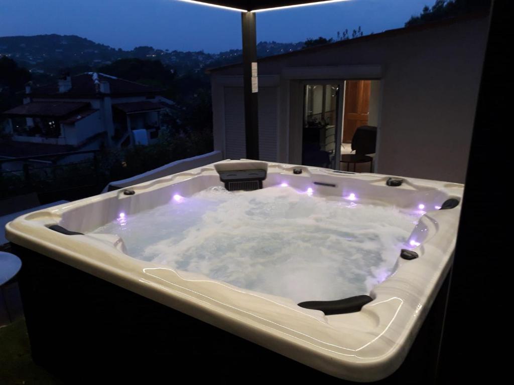 wanna z hydromasażem i oświetleniem na balkonie w nocy w obiekcie Piscine-Jacuzzi-Vidéoprojecteur-Clim La Perle Rare w mieście Mougins