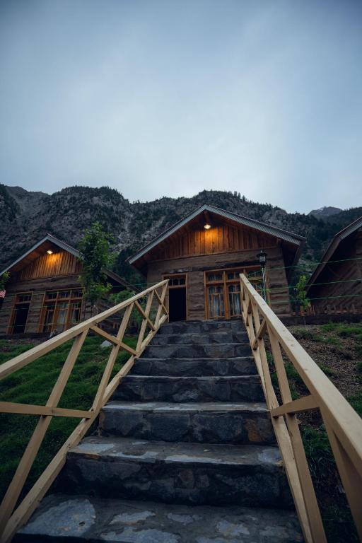 a stairway leading up to a wooden cabin with a building at Azure Lagoon Resort 
