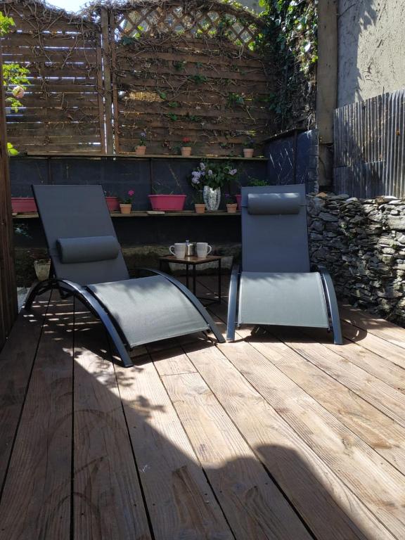 deux chaises et une table sur une terrasse en bois dans l'établissement Charmante cabane de pêcheur, à Cancale