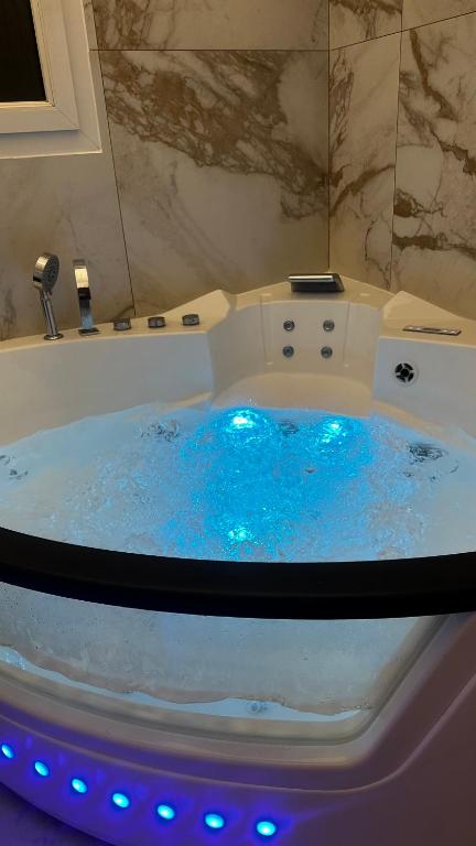 La salle de bains est pourvue d'une baignoire avec des lumières bleues. dans l'établissement Appartement pret de la Mer, à Nice