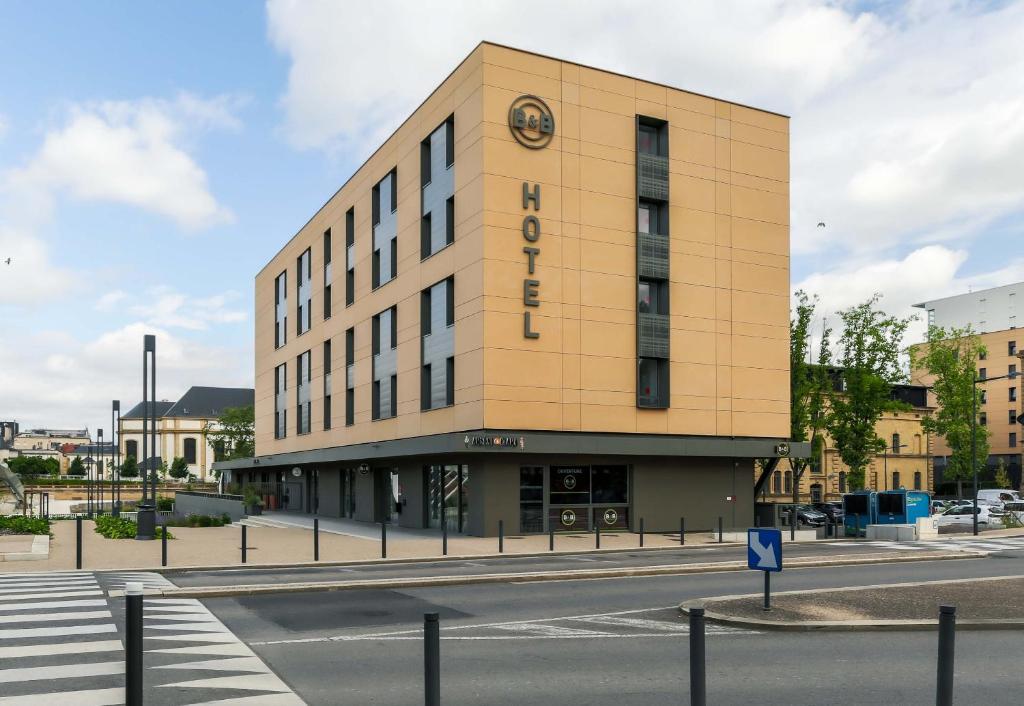 un bâtiment avec une horloge sur le côté dans l'établissement B&B Hôtel Thionville Centre Gare Porte du Luxembourg A31, à Thionville