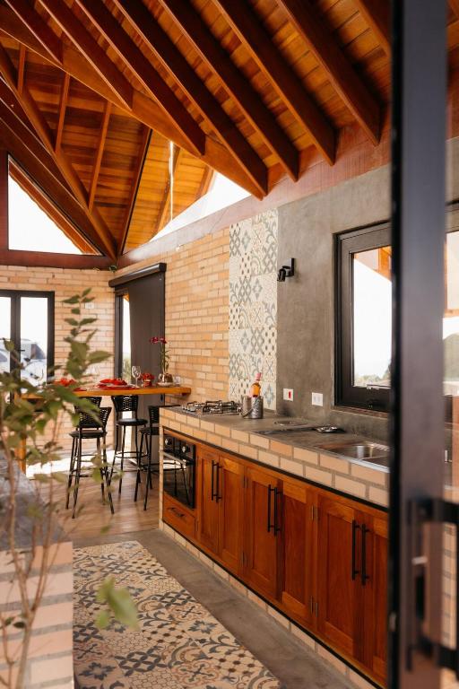 a kitchen with wooden cabinets and a table in it at Chalé Além do Horizonte in Bom Repouso