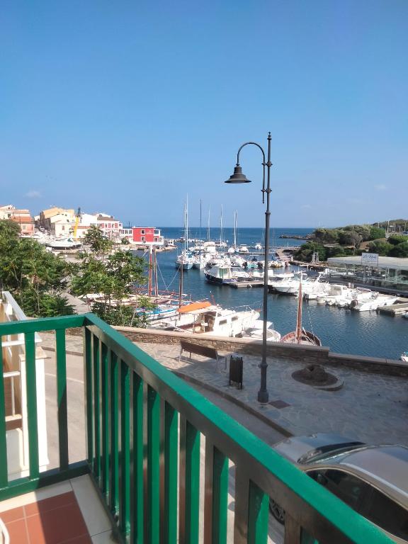 a balcony with a view of a marina with boats at casetta sul porticciolo in Stintino