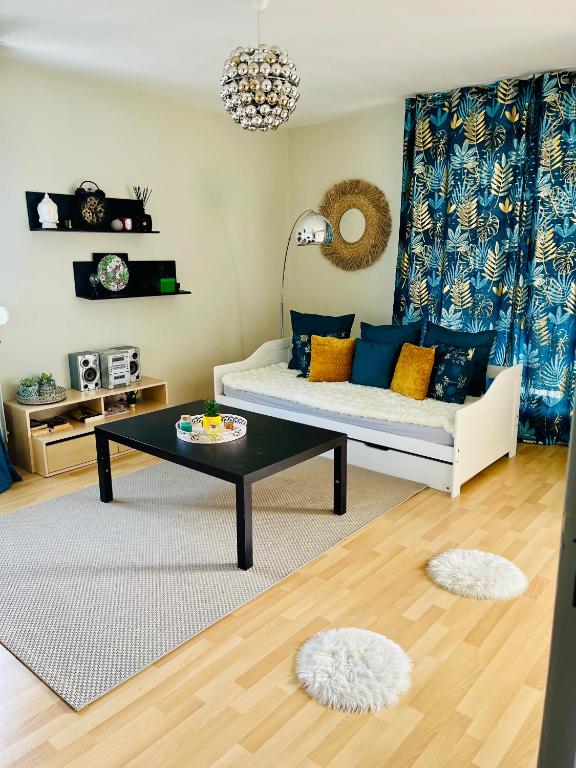 un salon avec un canapé et une table basse dans l'établissement Appartement agréable spacieux, à Clermont-Ferrand