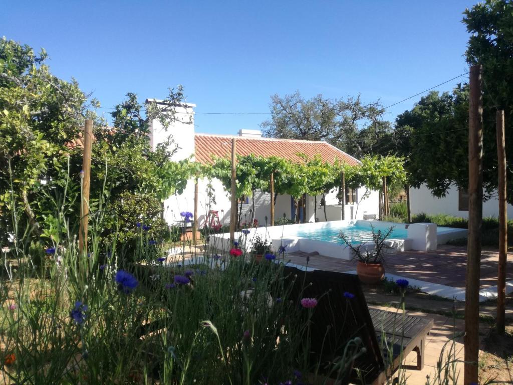 a garden in front of a house with a swimming pool at Bombom Comporta in Melides