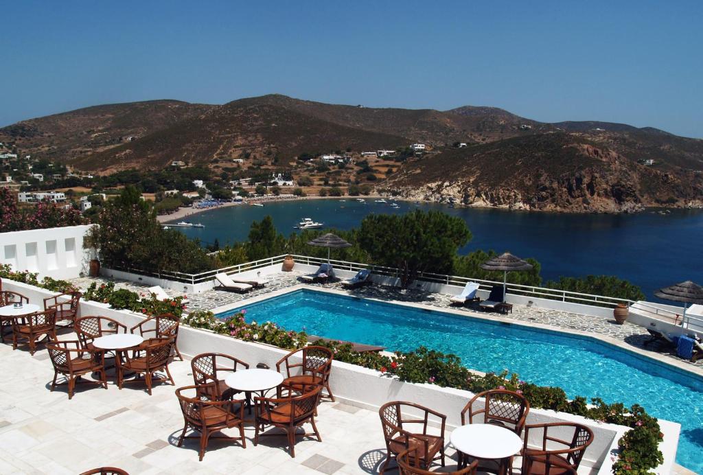 a view of the pool at a resort with tables and chairs at Patmos Paradise Hotel in Kámbos
