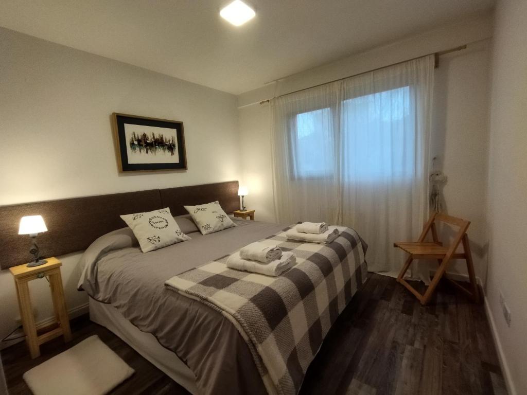 a bedroom with a bed with two towels on it at Amado Sur Apartment in San Carlos de Bariloche