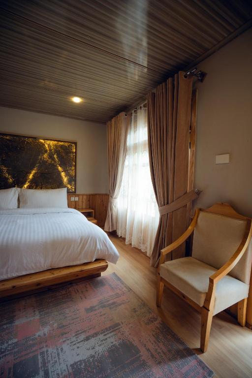 a bedroom with a bed and a chair and a window at Azure Lagoon Resort 