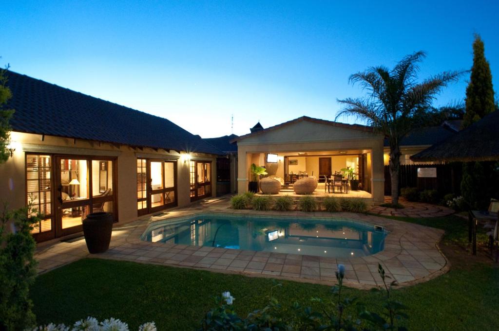 a house with a swimming pool in the yard at Rise and Shine Lodge in Bloemfontein