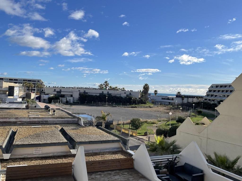 - une vue sur un parking avec des bâtiments et l'océan dans l'établissement Studio F32 Héliopolis - 2 personnes, au Cap d'Agde