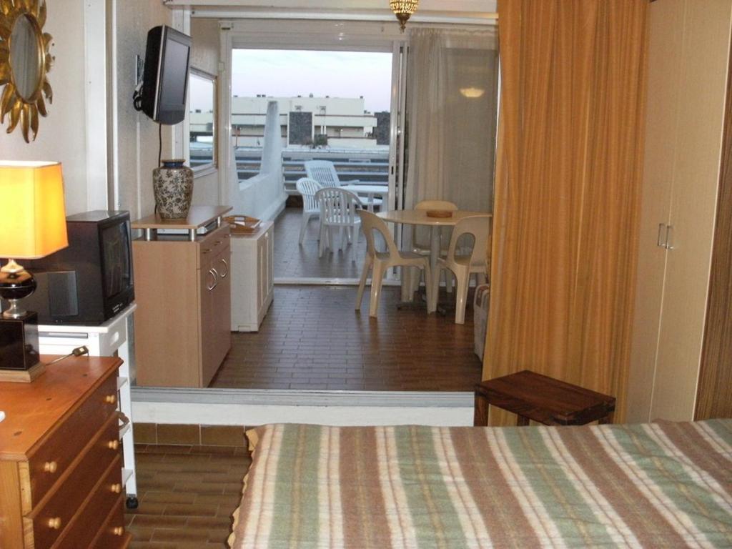 Cette chambre comprend un lit, une télévision et un balcon. dans l'établissement Héliopolis Studio F28 - 4 personnes, au Cap d'Agde