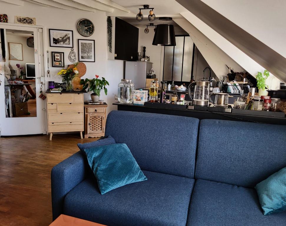 - un canapé bleu dans un salon avec une cuisine dans l'établissement Martyrs 