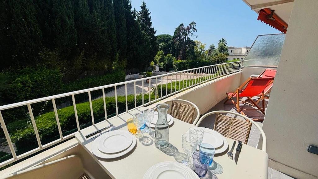 d'un balcon avec une table et des assiettes. dans l'établissement Proche Palais Des Festivals, plage 5min - Palmazur Vacances, à Cannes