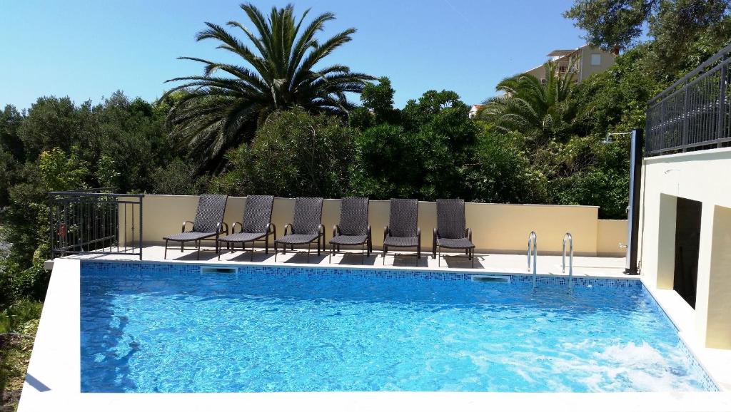 una piscina con sillas y una piscina en Apartments Kust, en Mlini