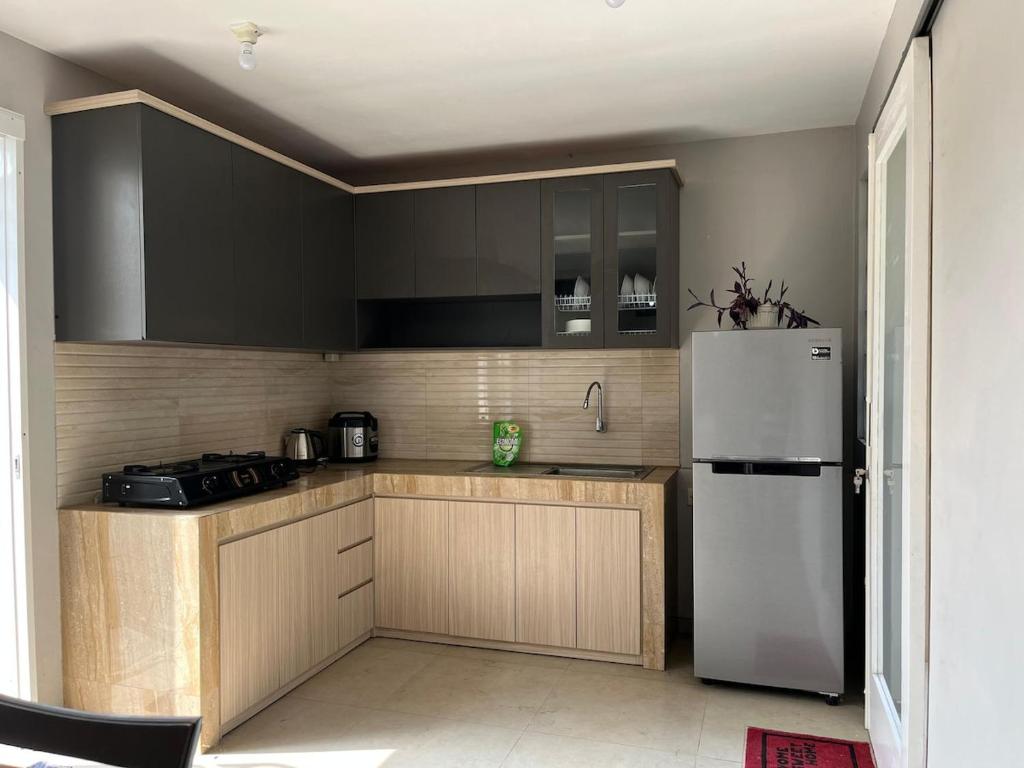 a kitchen with black cabinets and a white refrigerator at Villa Sultana Malang in Malang